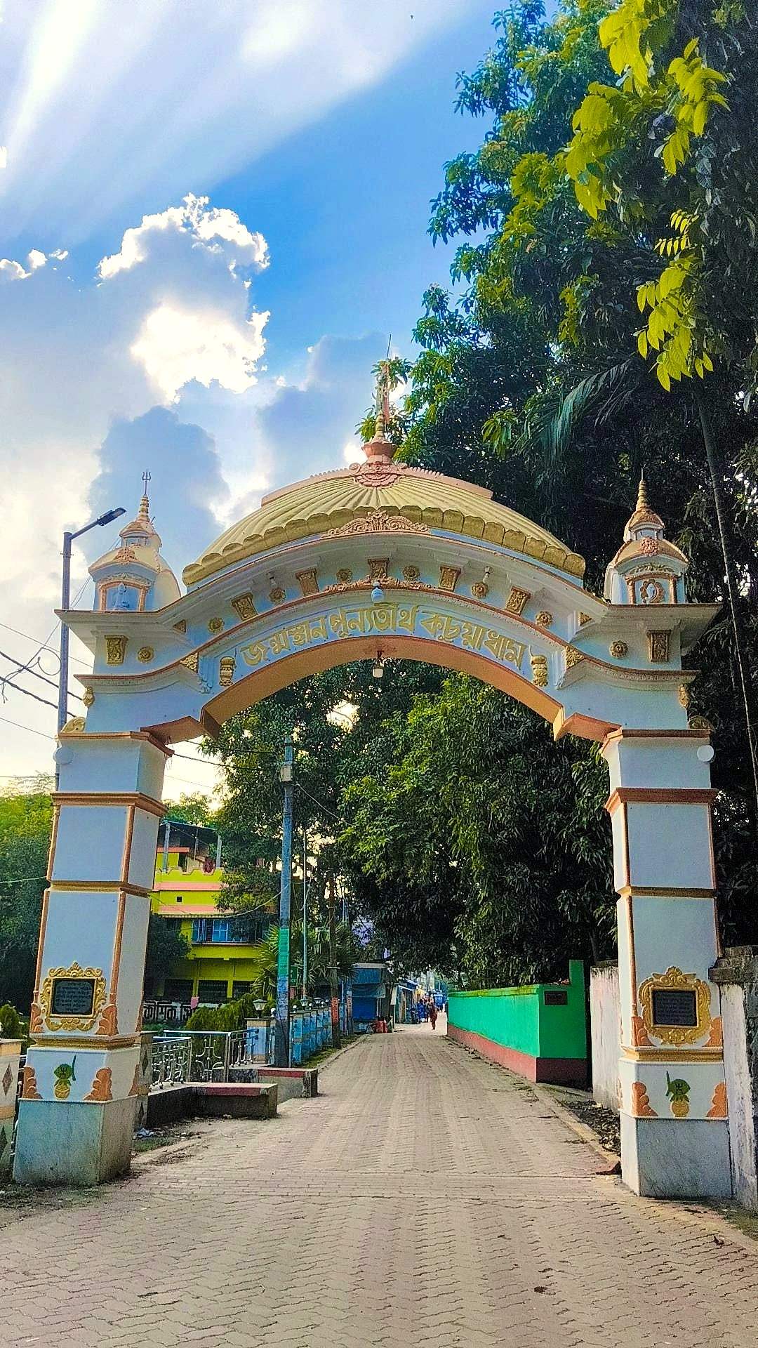 An ornate temple gateway under a bright blue sky