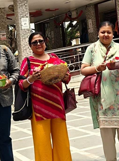 Two travellers carrying flower offerings on an ECHEPURON outing